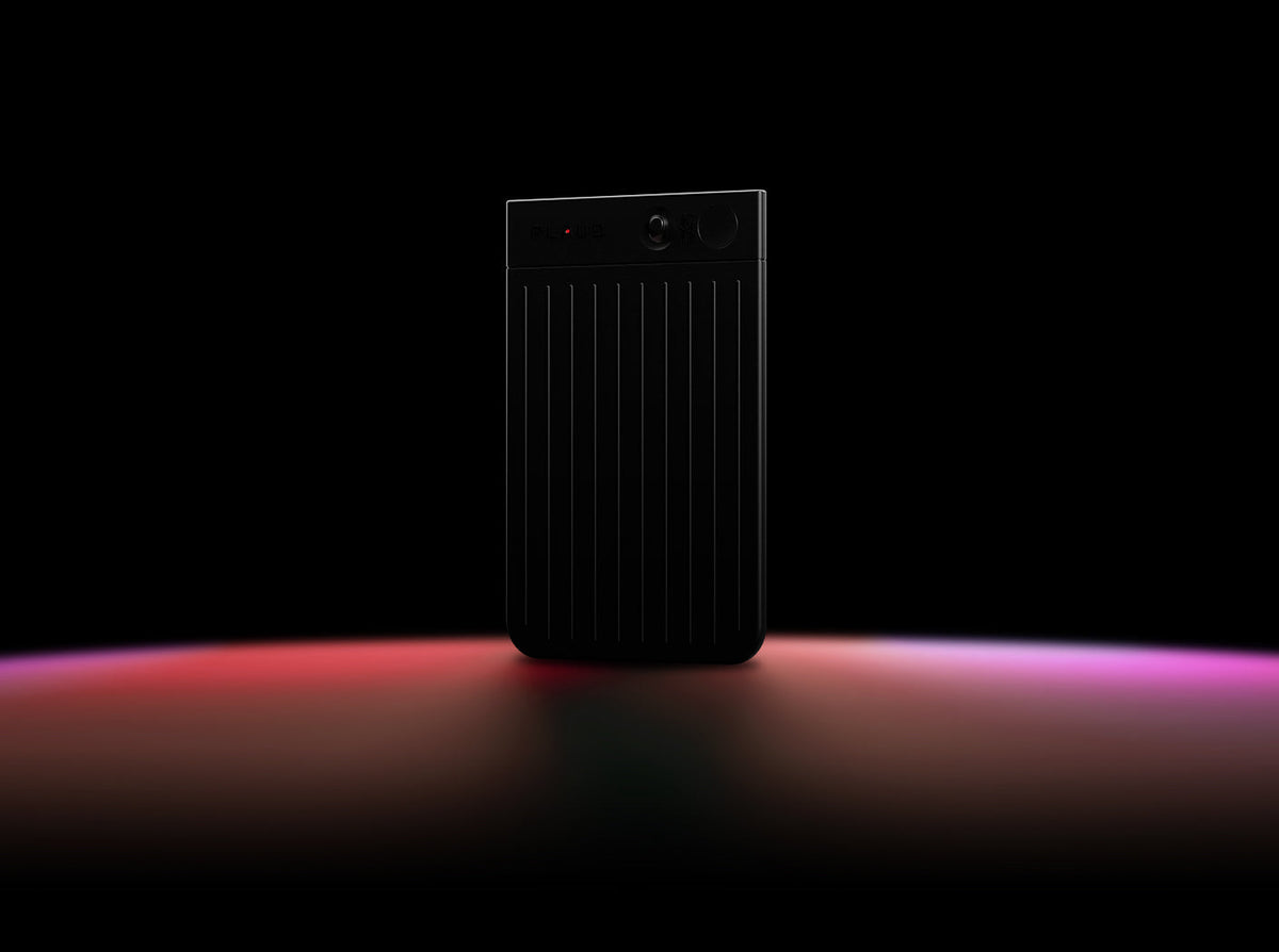 Black Plaud Note Pro AI voice recorder with a ribbed texture and display screen on a dark background.