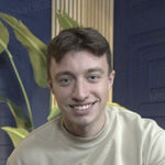Smiling young man with short brown hair and blue eyes.