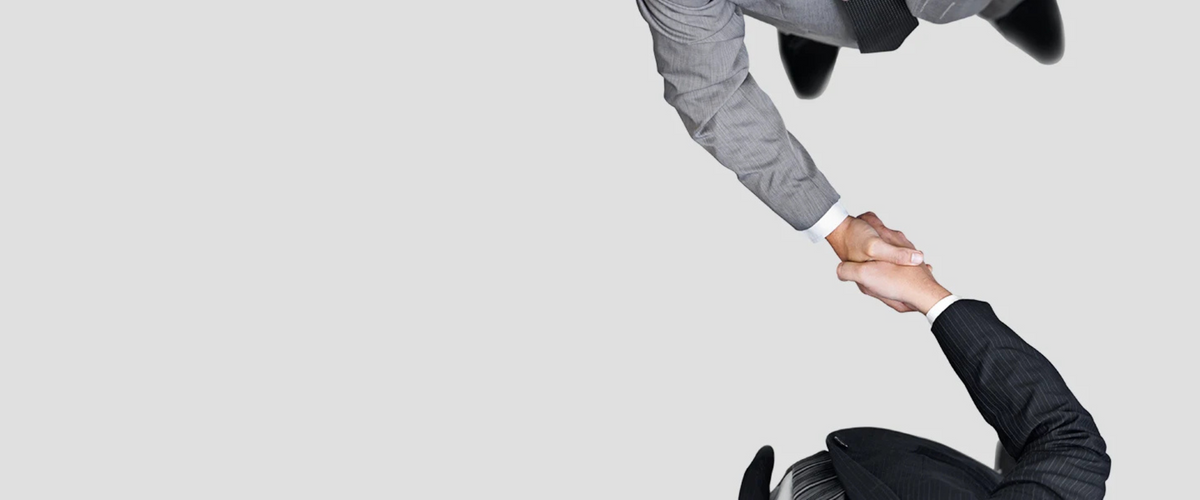 Top-down view of two business professionals shaking hands.