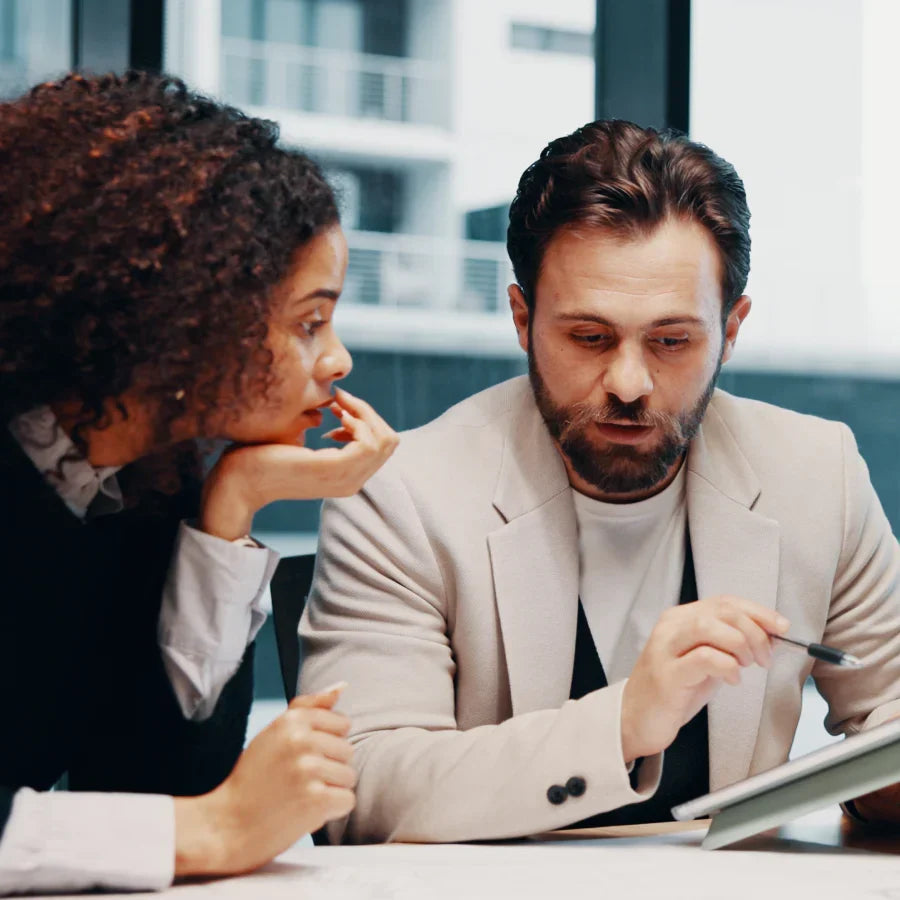 Two professionals collaborate in a meeting, a scenario for using a Plaud AI voice recorder.