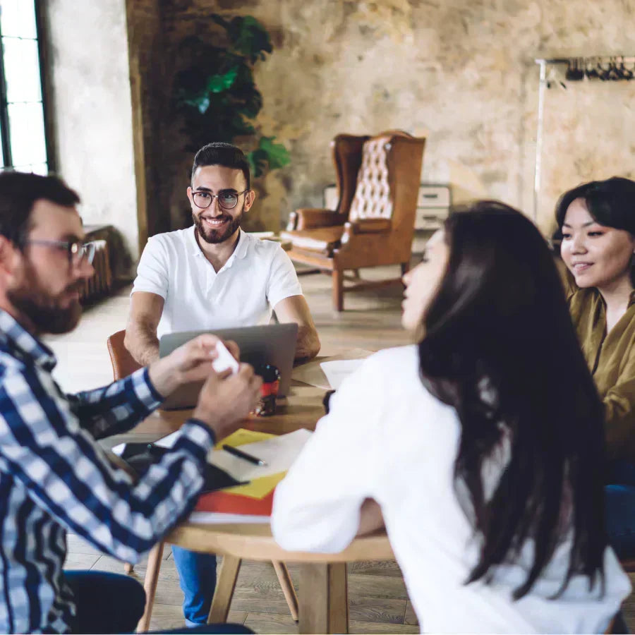 Team meeting with a professional holding a white Plaud Note AI voice recorder for transcription.