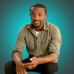 A man in an olive shirt holding a smartphone with a black Plaud Note attached, against a teal background.
