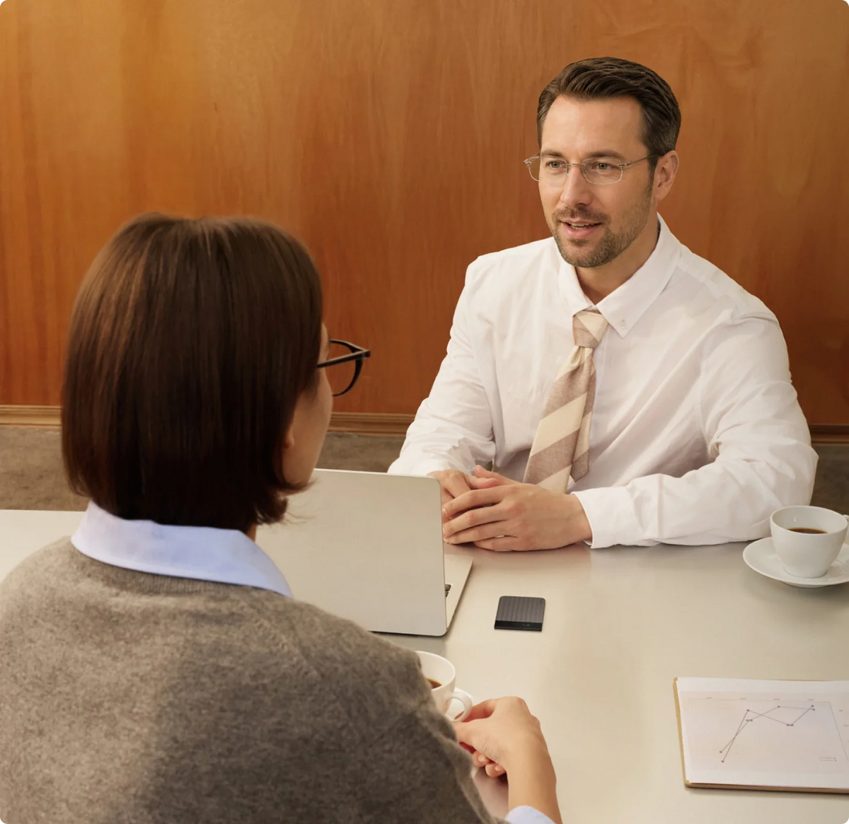 An HR professional interviews a candidate, recording with a Plaud Note Pro to make review easy.