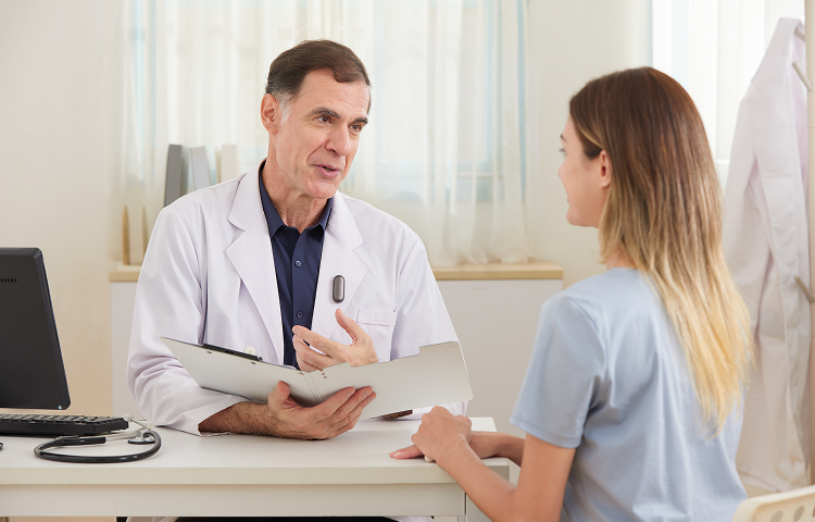 Doctor wearing a black Plaud NotePin on his lapel while speaking with a patient.