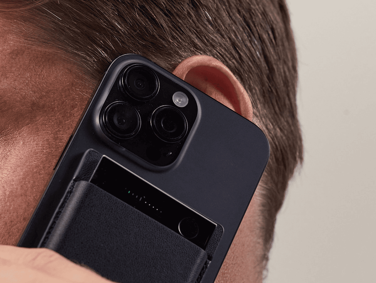 Black Plaud Note AI voice recorder attached to the back of a smartphone during a phone call.
